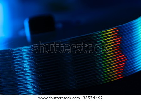 Stack of audio CD and rainbow reflection. Compact disks in blue light. Diagonal view