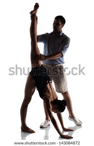 Silhouette of a beautiful female ballet dancer and dance teacher isolated on a white background. Ballerina is barefoot and wearing a dark leotard and short dress. Instructor in plain clothes.