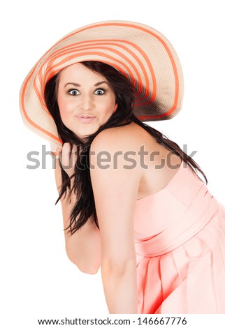 Cute young funky fashion girl wearing a pink coral dress and summer hat.