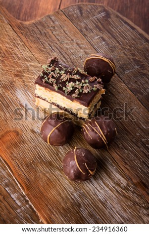 A selection of delicious chocolate truffles and cake served on a wooden board.