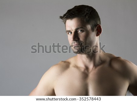 Portrait of an attractive young caucasian athlete. The man is posing and flexing his muscles.