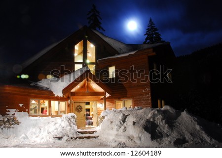 Winter snow scene of a cabin at Lake Kachess at night with moonlight.