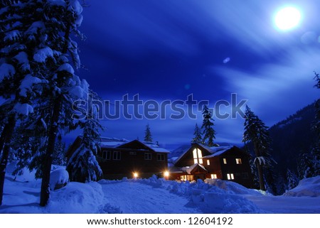 Winter snow scene of a cabin at Lake Kachess at night with moonlight.