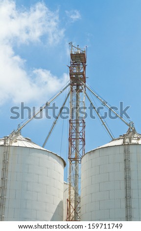 Big white tanks in factory under blue sky