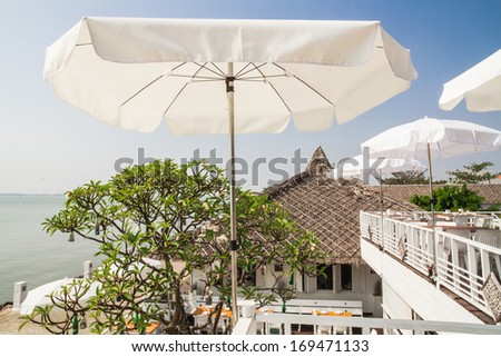 White umbrella on white wood terrace