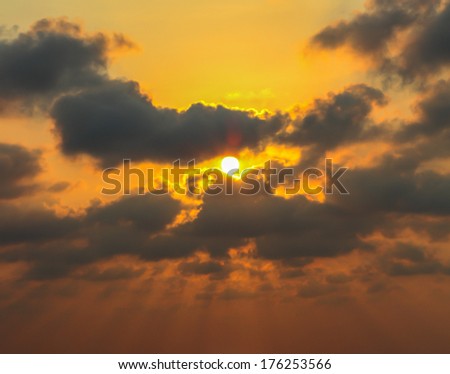 Black cloud and golden sky under sunshine before sunset
