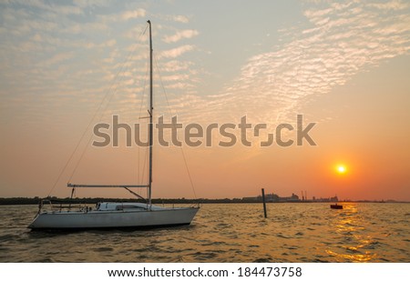 White sailboat and golden sky before sunset