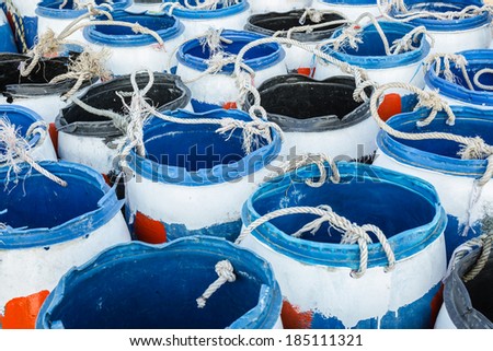 The painted blue plastic barrels and rope