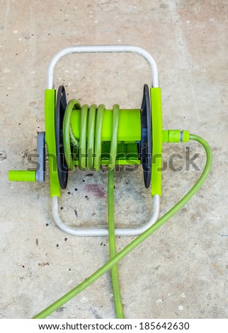 Watering garden hose on cement floor