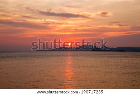 Red sun and beautiful sky over golden sea in sunset time
