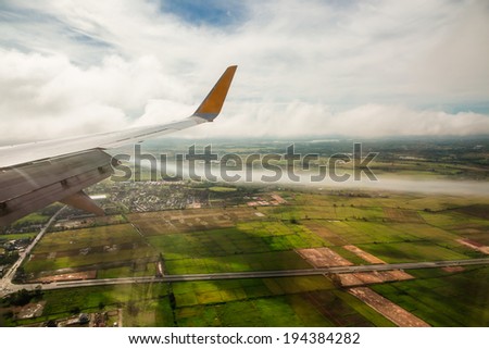 Wing and white smoke before airplane landing down