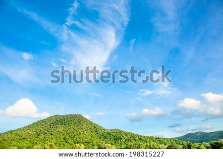 Green mountain and white cloud under blue sky