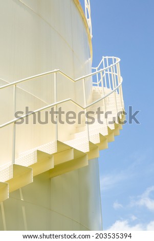 Stair and big yellow tank in sunshine day