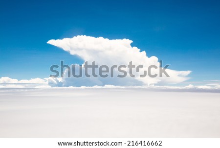 White cloud and blue sky, view from the window of an airplane flying above the cloud