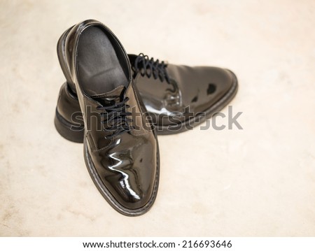 Black shiny leather shoe on blare cement floor