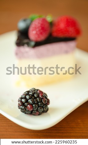 Mulberry  and slice of fresh berries and strawberry on layer sponge cake