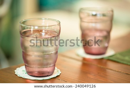 Pink glass of drink water on wooden table