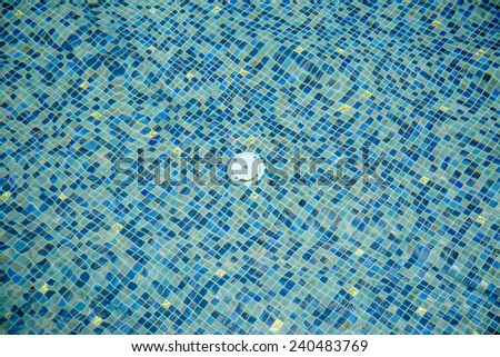 White drain water and colorful ceramic floor under water in swimming pool