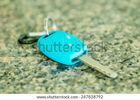 Car key in green silicone on polished stone