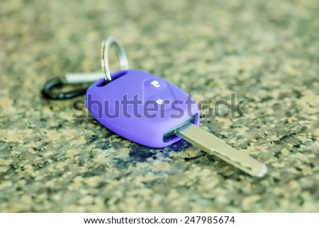 Car key in purple silicone on polished stone