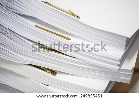 Stack of paper files with golden clips