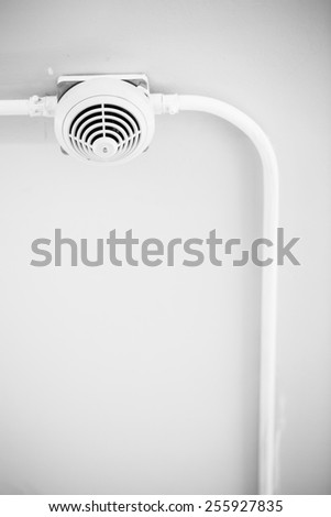 Smoke detector sensor on cement ceiling in black-white tone