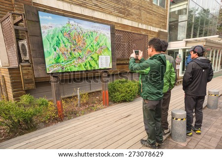 SEORAKSAN,SOUTH KOREA - APRIL 14 :The tourists are reading information map at Cable car station at the Seoraksan National Park on April 14, 2015 in Seoraksan, South Korea.