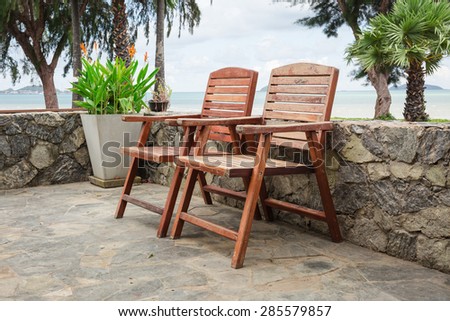 Wooden chairs on stone terrace beach in summer