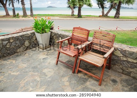 Wooden chairs on stone terrace beach in summer