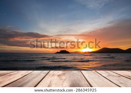 Wooden plates on sea scape and golden sky before sun set background