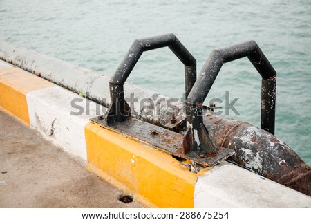 Black dilapidated ladder on port