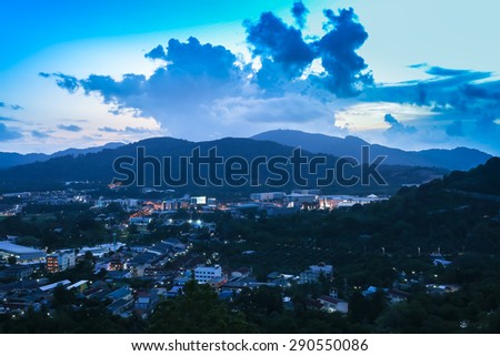 Industrial city and big mountain under cloudy sky in twilight time