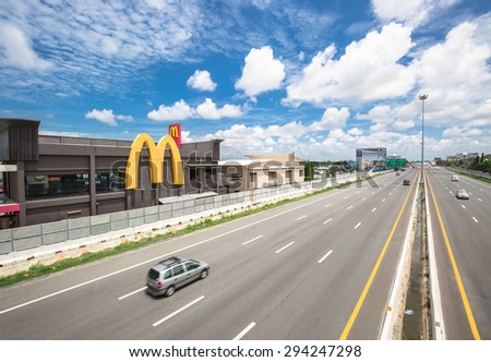 CHONBURI-THAILAND - JULY 6 : The wide lanes with high speed cars and Mcdonalds restaurant building on the motorway from Bangkok to Pattaya on July 6,2015