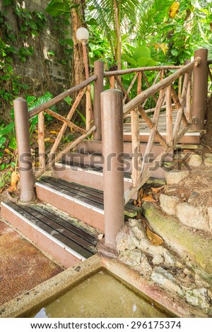 Wooden stair under green trees on sea beach