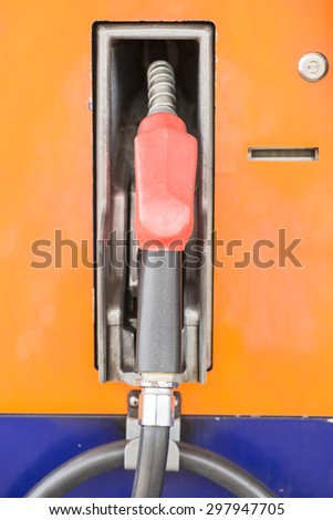 Orange hoses of petrol pump at a gas station
