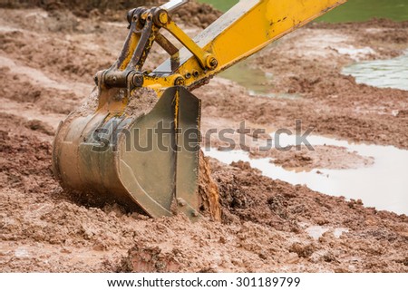 Big digger with brown mud on coastal lake