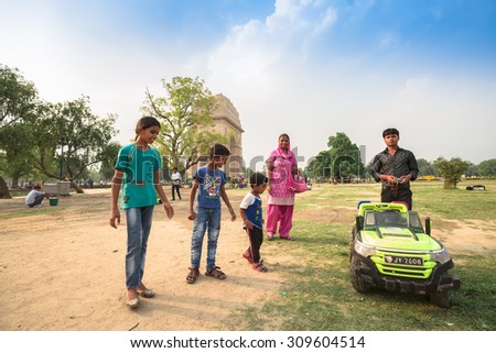 NEW DELHI, INDIA - AUGUST 4: The children and parents are interesting about mini motor car for rent at the public park around Indian gate in summer in New Delhi,India on August 4, 2015.