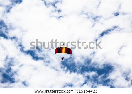 Skydiver and colorful parachute  on white cloud blue sky background