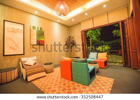 AMPAWA, THAILAND - DECEMBER 15: The living room interior design with sofa, armchair and colorful pillows in famous vintage hotel at ancient Ampawa, Thailand on December 15, 2015.