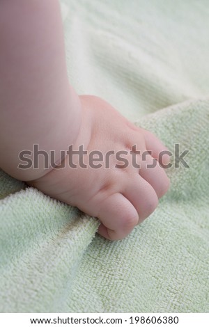 Baby hand grabs a blanket