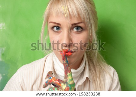 Attractive woman with hands and lips covered with paint makes a hush and secret gesture