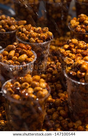 Groundnuts tiger nut in plastic glasses watered with water in fair exhibitor