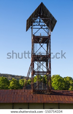 head frame ( tower elevation ) of old hangar mine shaft and closed between trees  and vegetation highland . Sabero .  Leon . Spain