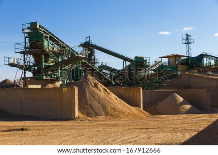 Used gravel pit near the river to mills, conveyor belts and piles of sand