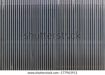 Linear geometric background or texture silvery gray color. Metal structure covered car park facade