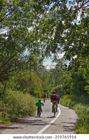 Cyclist on Bike Path - Cyclists circulating bike lane on the outskirts of a city and among trees with sun