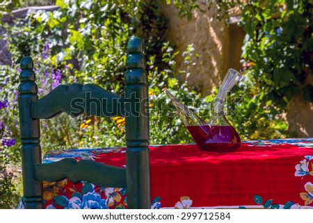 Wine drinking vessel typical of Spain ( Porron ) Decanters with sangria on a table in the shade of summer in the garden or backyard