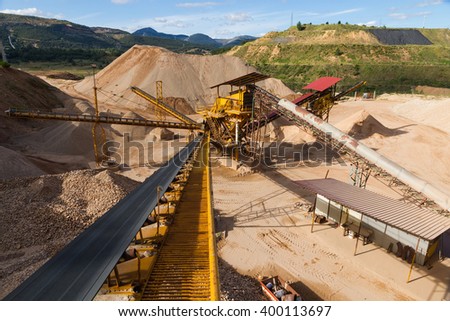 Gravel Aggregate Extraction - Gravel pit in mountain area with machinery and distribution tapes gravel according sizes, lots of gravel and sand for construction industry