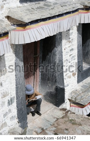 man sitting on door step of Potala palace