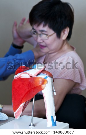 Shoulder-model with asian woman is being treated in the background